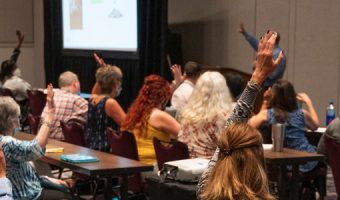 People raising their hands during training