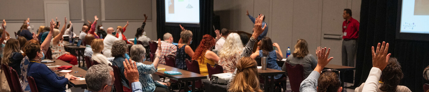 People raising their hands during training
