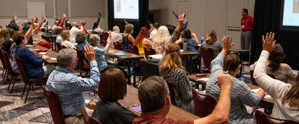 People raising their hands in a classroom